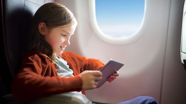 Girl on tablet inside airplane